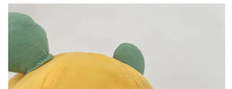 Infant baby frog bucket hat with smiling frog face, adding a fun touch to sun protection. Children's hat.