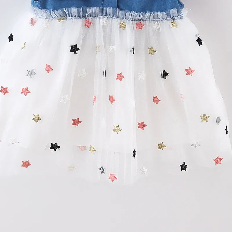 Detail of the soft denim fabric of a girls' dress, highlighting the bow and flying sleeves.