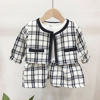 Close-up of a baby girl's red plaid coat with black buttons, ideal for autumn wear