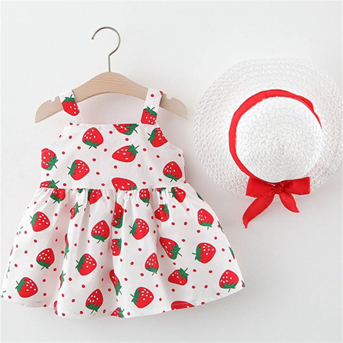 Toddler girl's summer outfit: pink strawberry print dress and wide-brimmed sun hat, cotton blend.