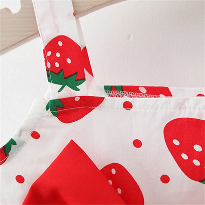Close-up of strawberry print fabric on a baby girl's dress, showing vibrant design and texture.