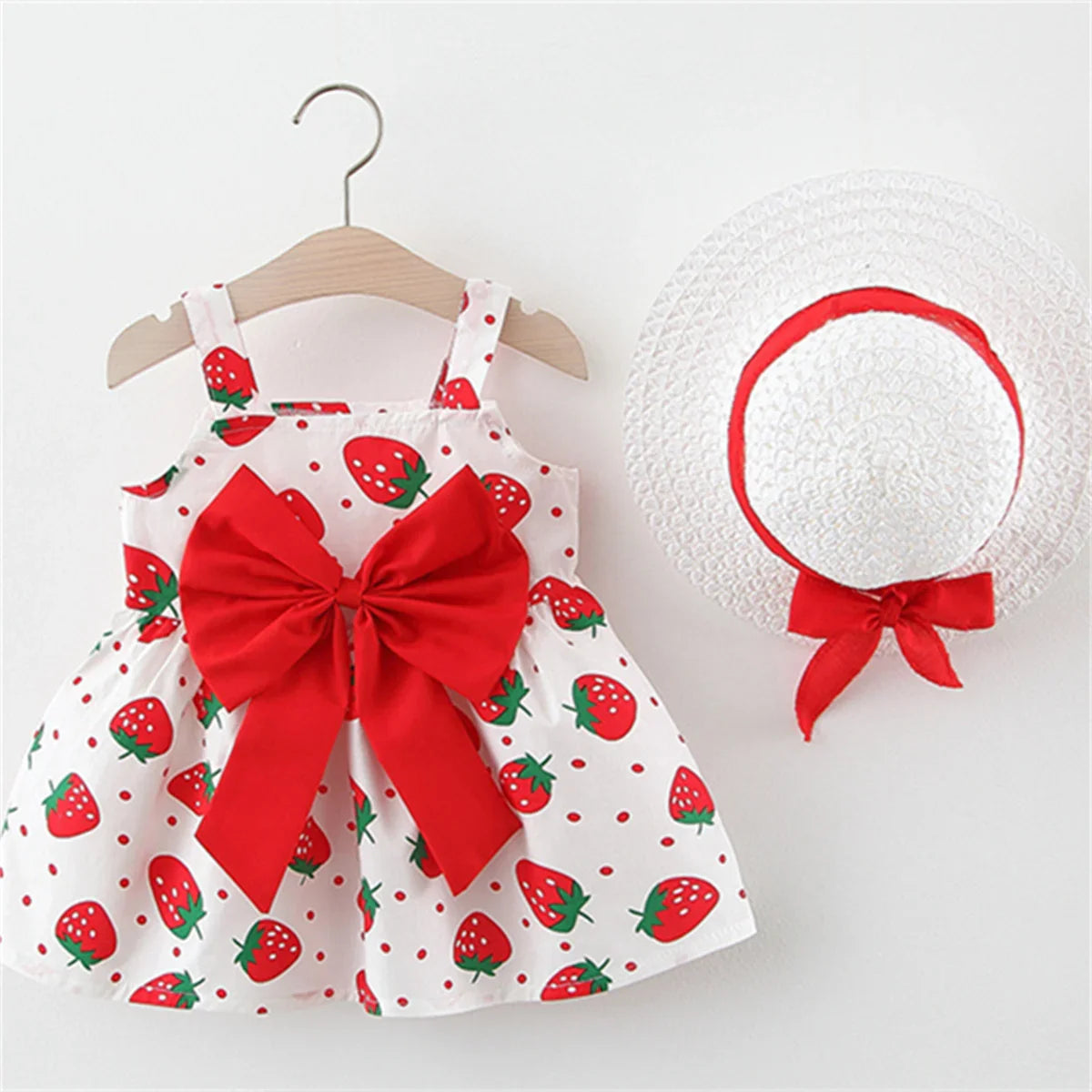 Sweet baby girl's outfit: strawberry adorned dress and sun hat for a playful, sunny day look.