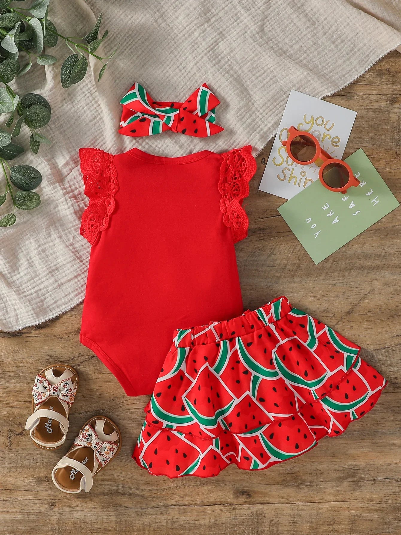 Close-up of cute infant girl's watermelon print bodysuit from a 3-piece summer outfit set