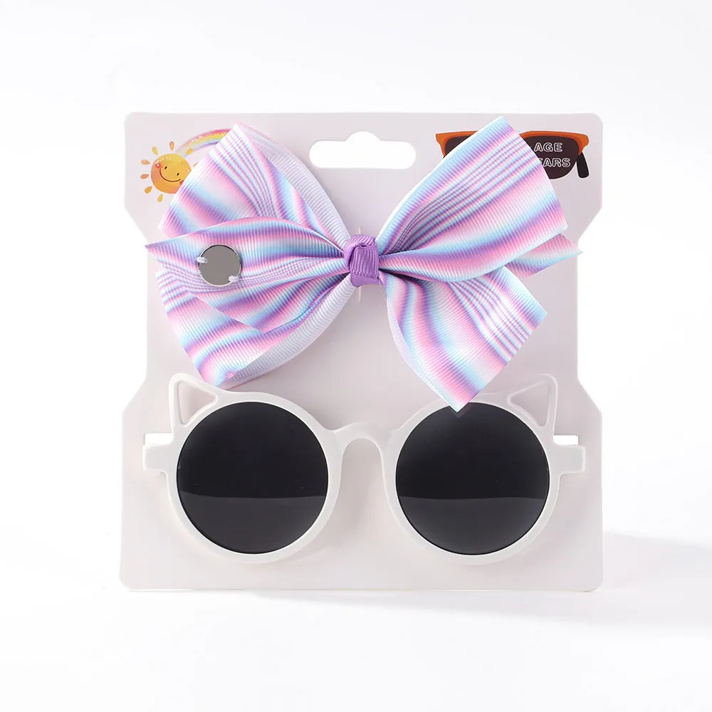 Cute baby girl's fashion accessories: a sweet bow and fun cartoon sunglasses for toddlers.