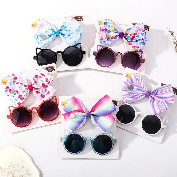 Charming baby girl's bow & cartoon sunglasses combo. Perfect for stylish infant outfits.
