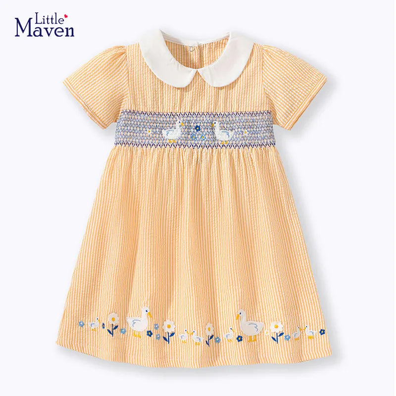 Closeup of cheerful yellow duck applique on a sleeveless baby girl's cotton blend summer dress.