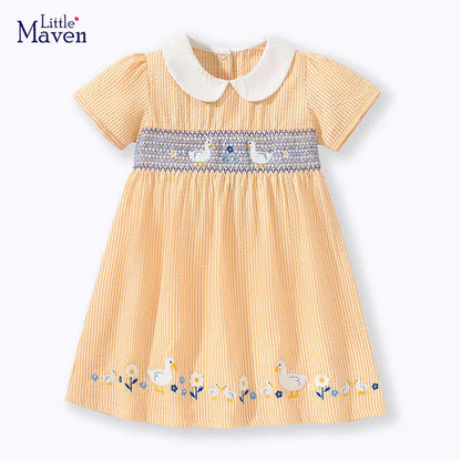 Closeup of cheerful yellow duck applique on a sleeveless baby girl's cotton blend summer dress.