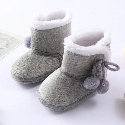 Close-up of a pink baby girl winter boot showing soft faux fur lining and durable anti-slip sole.