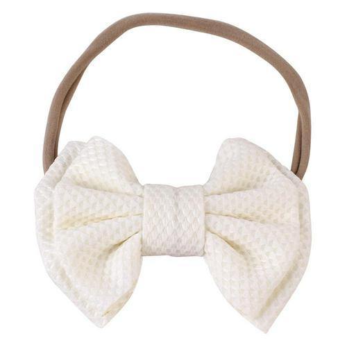 Toddler girl wearing a cute pink elastic bow headband, showing comfort and style.