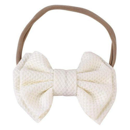 Toddler girl wearing a cute pink elastic bow headband, showing comfort and style.