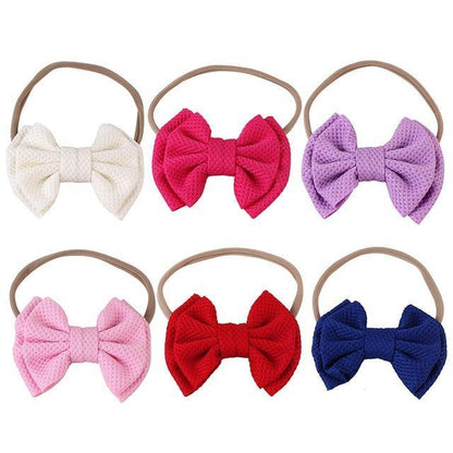 Packaging of a baby girls' elastic bow headband, highlighting its cute design.