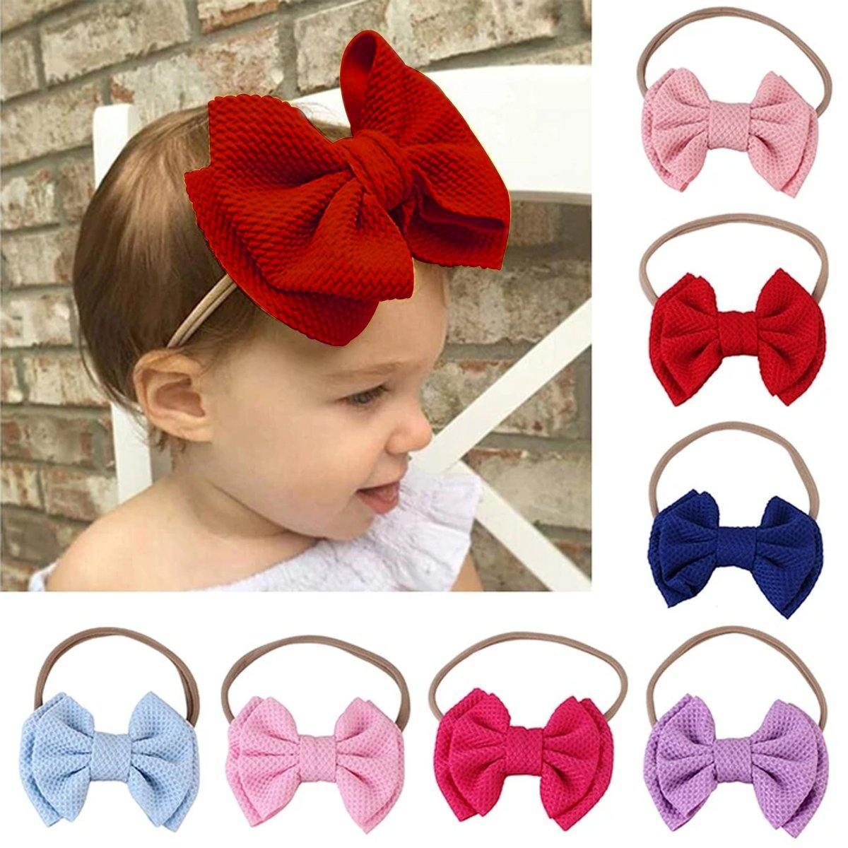 Baby girls' elastic bow headband in a gentle pastel color, a sweet accessory.