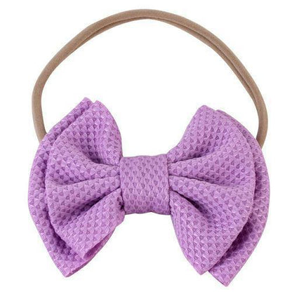 Purple elastic bow headband for baby girls, adding a pop of color to their outfit.