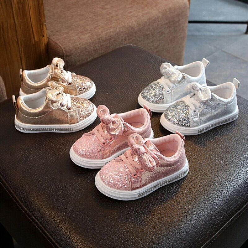 Close-up of sparkling glitter bowknot detail on baby girls' first walker shoes.