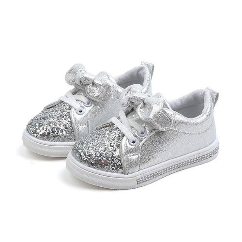 Pair of stylish infant girl's glitter sneakers with delicate bowknot, perfect for first steps.