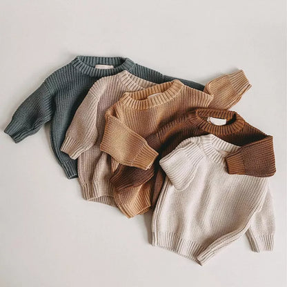 Adorable baby in a cozy knitted loose sweater, perfect for autumn winter warmth and comfort.
