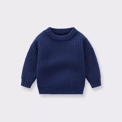 Cute baby in a soft, loose-fitting knitted jumper, ideal for chilly autumn winter weather.