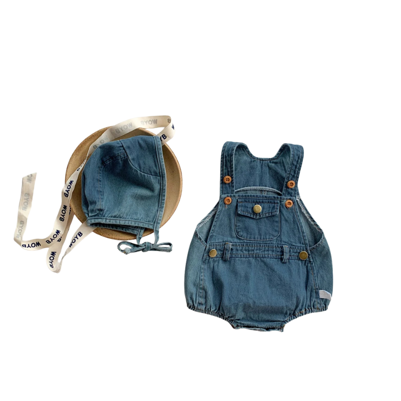 Close-up of the delicate texture of the cotton baby romper and bonnet, highlighting the soft fabric.