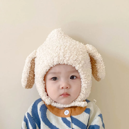 Adorable baby in a pink plush rabbit ears winter hat, perfect for warmth & cuteness.