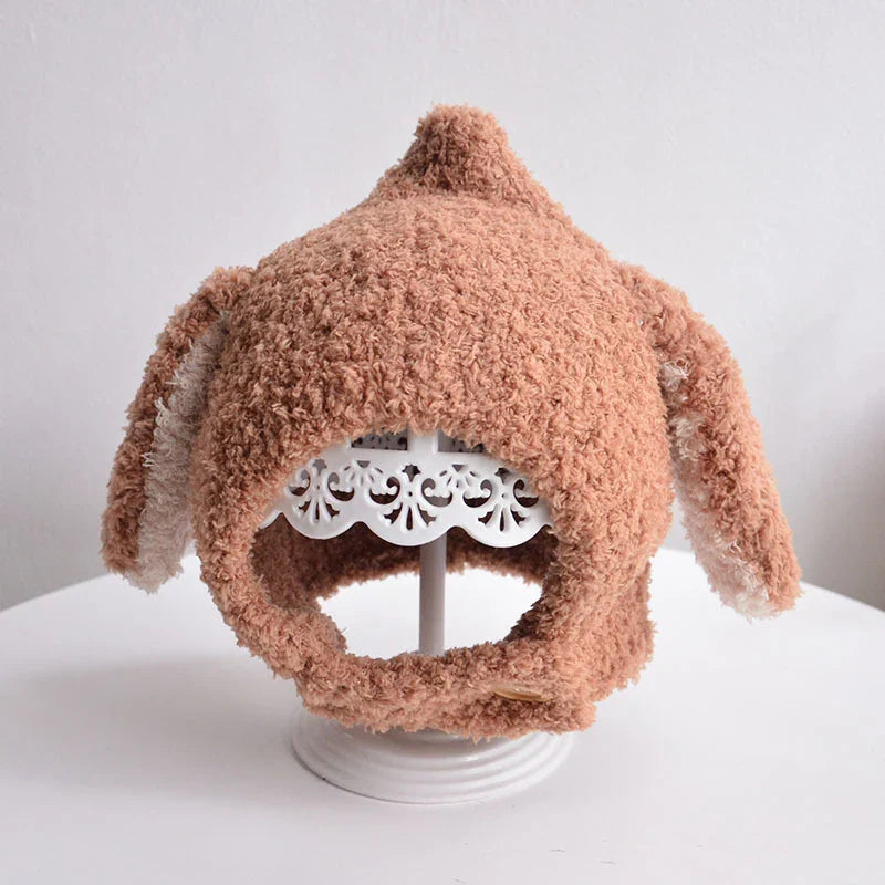 Playful baby in a yellow plush rabbit ears winter hat, a fun & functional accessory.