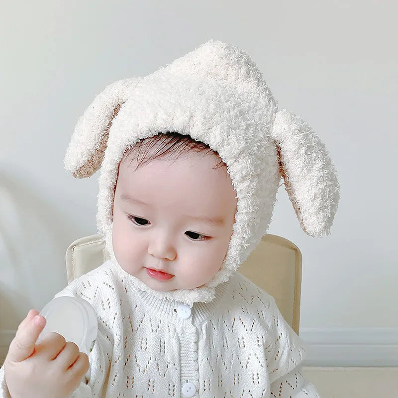 Cute newborn wearing a soft white unisex plush rabbit ears hat, essential baby accessory.