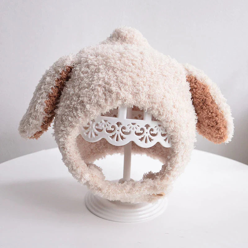 Baby boy looking cute in a light blue plush rabbit ears winter hat, keeps head warm.