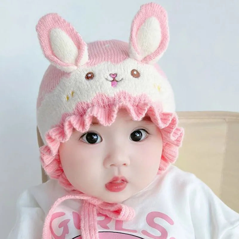 Adorable baby in a soft pink rabbit winter hat, perfect for keeping toddlers warm and cute.