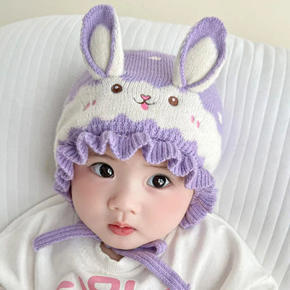 Baby's head and shoulders, showcasing a warm rabbit winter hat, ideal newborn accessory.