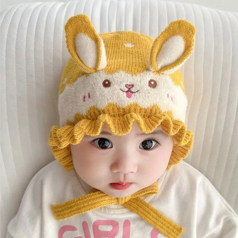 Toddler smiling, bundled in a fashionable rabbit winter hat, a soft and cute baby accessory.