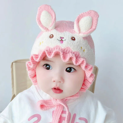 Infant wearing a plush rabbit winter hat, a must-have baby accessory for cold weather.
