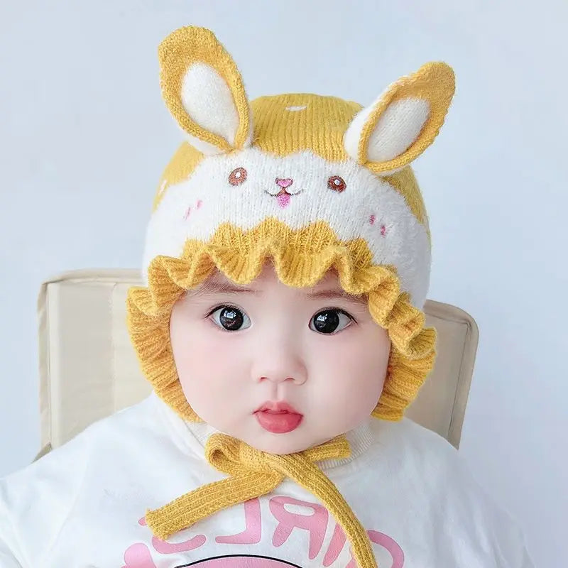 Cute baby model displaying a cozy rabbit winter hat, a fashionable newborn accessory.