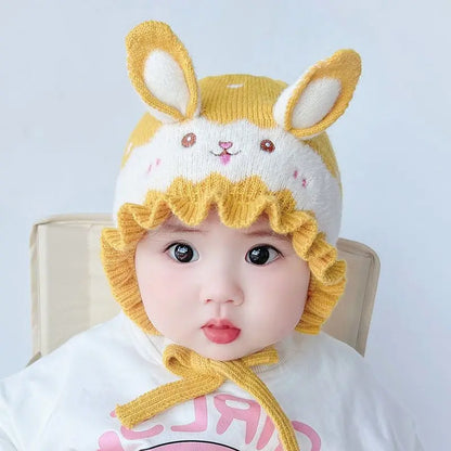 Cute baby model displaying a cozy rabbit winter hat, a fashionable newborn accessory.