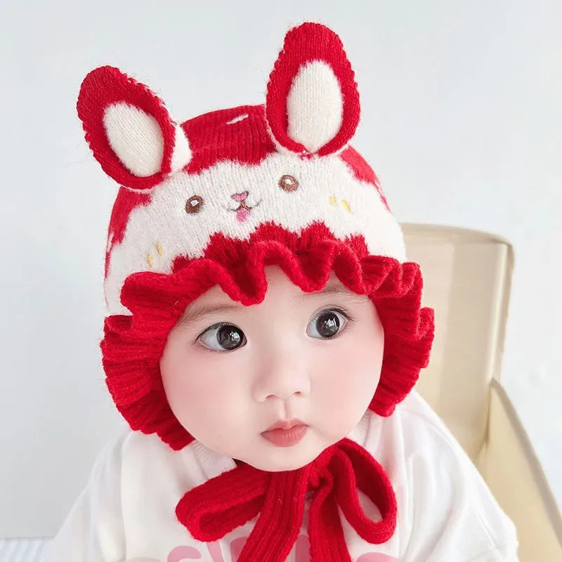 Side view of a toddler in a pink rabbit winter hat, soft and warm for winter adventures.