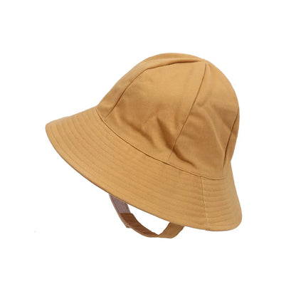 Toddler's head wearing a light blue adjustable sun protection bucket hat, eyes shaded from sun.