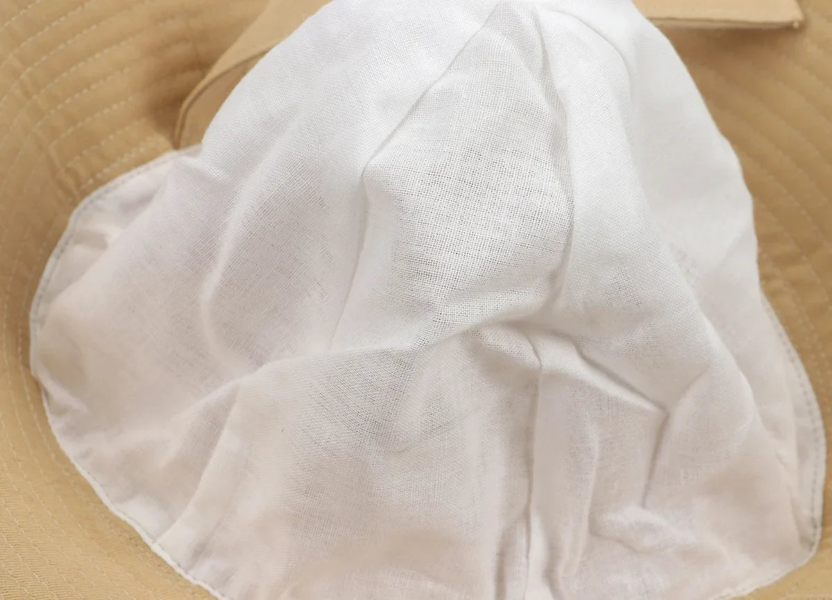 Close-up of the quick-dry fabric texture of an adjustable sun protection bucket hat, for infants.