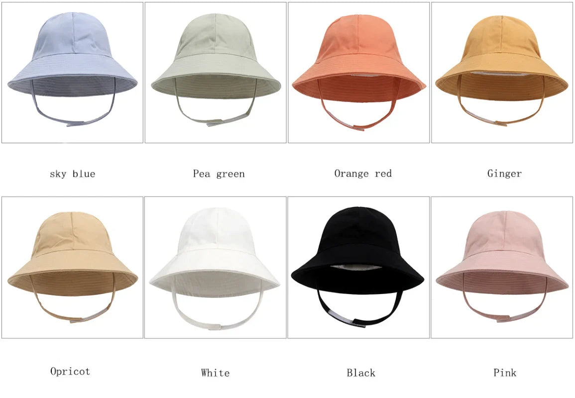 Infant wearing white adjustable bucket hat for sun protection, napping peacefully in a stroller.