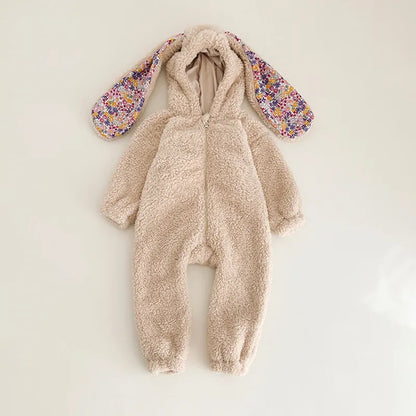 Close-up of a baby's face in a cute rabbit hooded romper, cuddly fleece outfit.