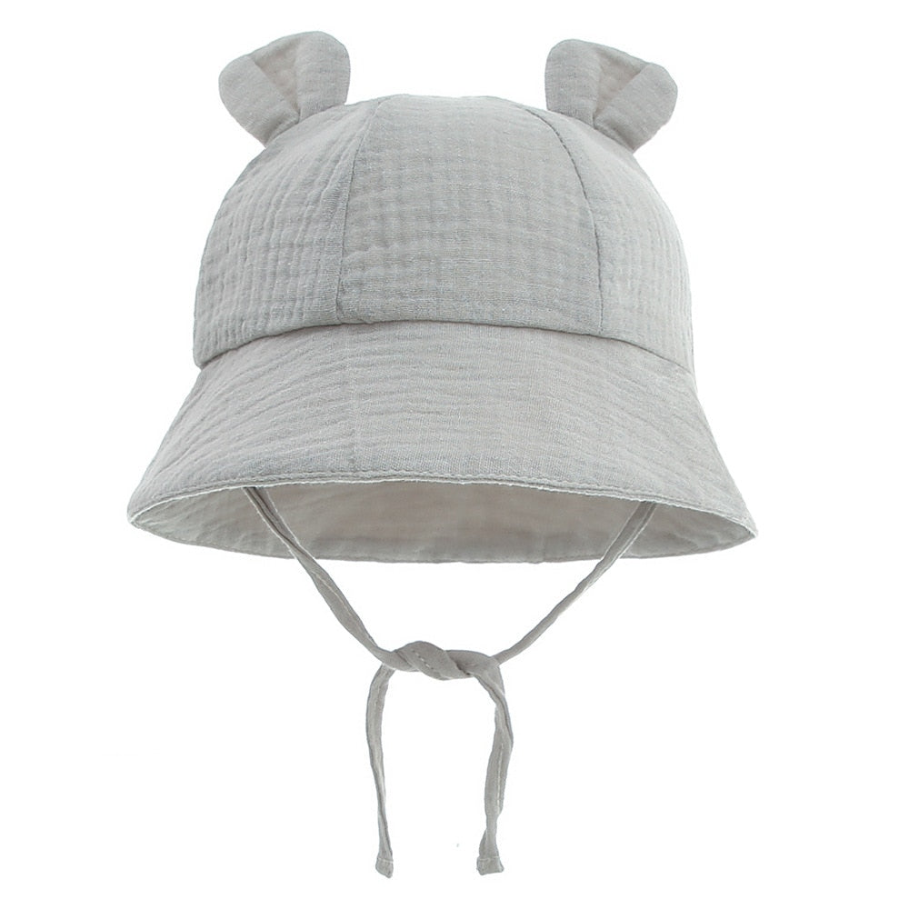 Smiling infant in a comfortable cotton fisherman sun hat, essential for outdoor toddler activities