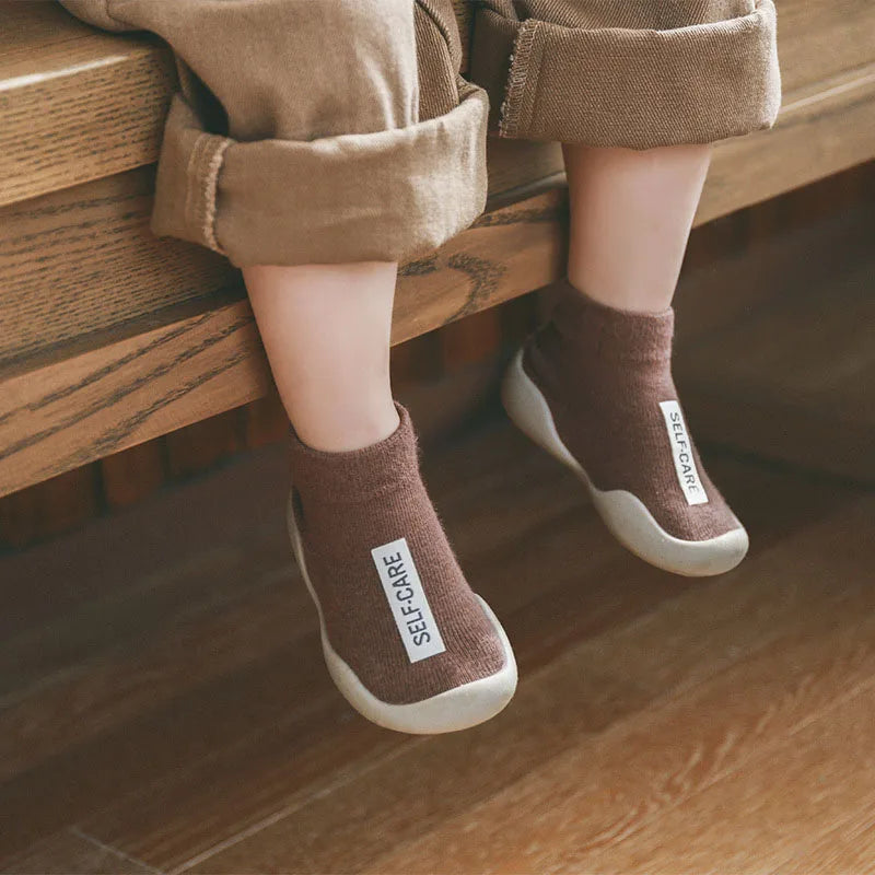 Close-up of a soft sole non-slip toddler walking shoe, showing knit texture and grip.