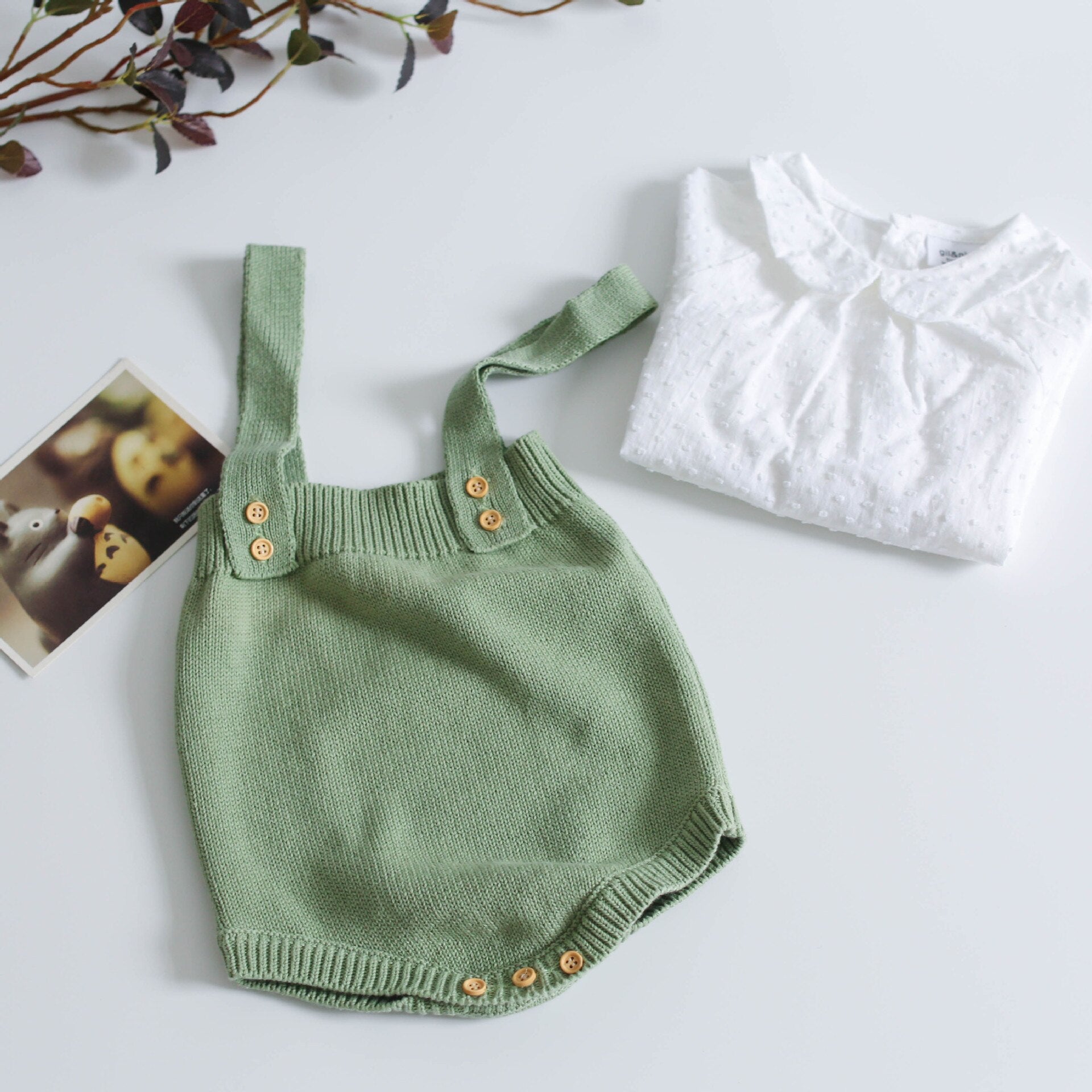 Model baby showcasing the comfortable fit of a hand-knitted romper, perfect infant clothing.