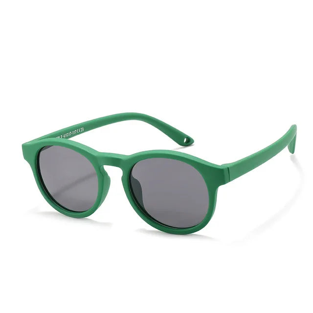 Lifestyle image of baby wearing orange polarized UV400 sunglasses at the beach, providing essential sun protection.