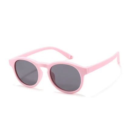 Infant peeking over teal polarized UV400 sunglasses, a playful image of baby fashion and eye protection.