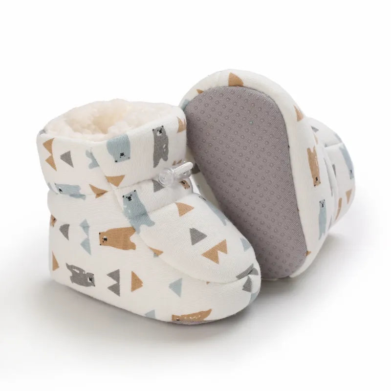 Close-up of a baby's foot in a warm animal-themed winter slipper with a secure non-slip soft sole.