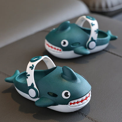 Side view of green cartoon shark slippers for children, emphasizing their flexible and durable construction.