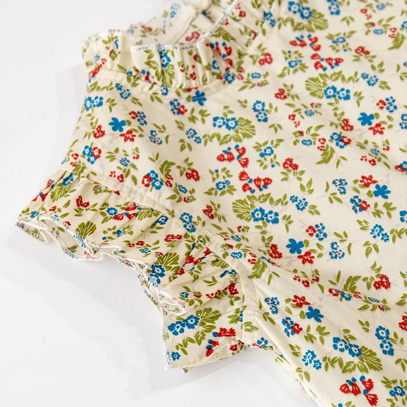 Close-up of the delicate floral pattern on a girls' summer top and skirt set made from cotton.