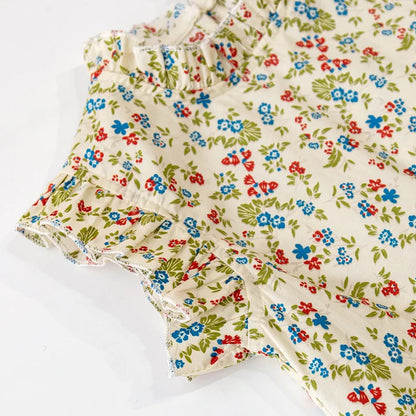 Close-up of the delicate floral pattern on a girls' summer top and skirt set made from cotton.