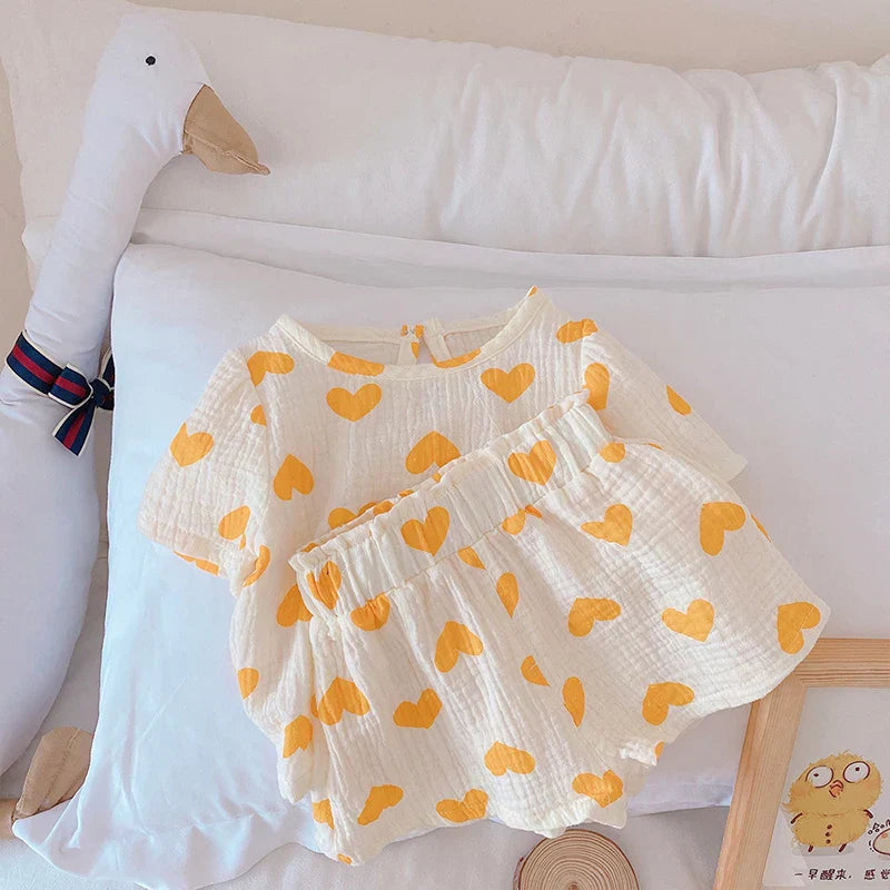 Toddler girl's summer set: red hearts on white cotton, short sleeves, comfy shorts. Kids fashion.