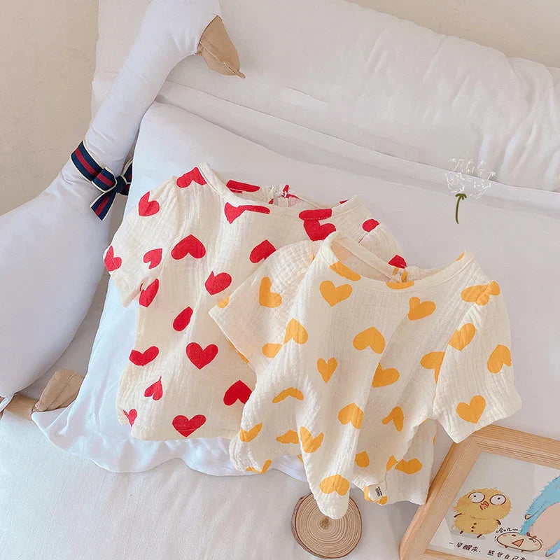 Close-up of heart print on a breathable cotton summer outfit for toddler girls. Ideal playwear.