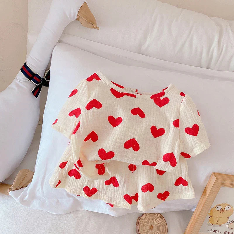 Girls' cotton shorts and top set with cute heart prints, designed for comfortable summer play.