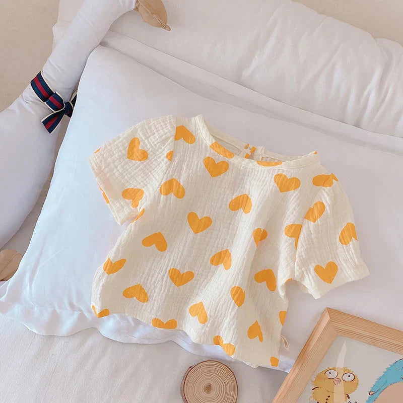 Vibrant heart pattern on a soft cotton summer outfit for baby girls. Durable and breathable.